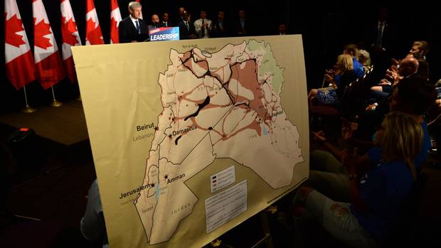 A map showing ISIL zones is displayed as Conservative Leader Stephen Harper delivers a speech during a campaign stop in Ottawa on Sunday, August 9, 2015. Harper announced that if re-elected his party would impose banned travel zones to combat terrorism. (Sean Kilpatrick/The Canadian Press)